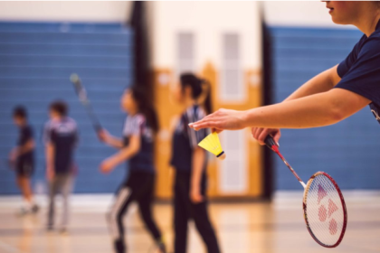Why is wrist action important in badminton, and not just arm action?