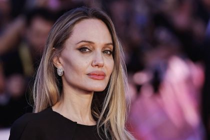 Angelina Jolie showcases her tattoos in plunging black gown